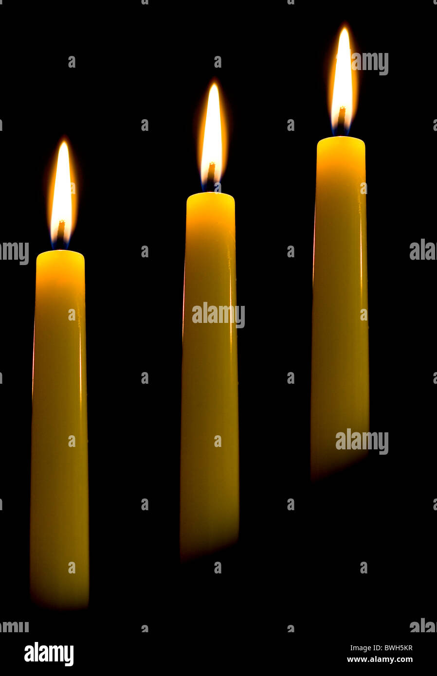 Three candles in line with flames Stock Photo Alamy