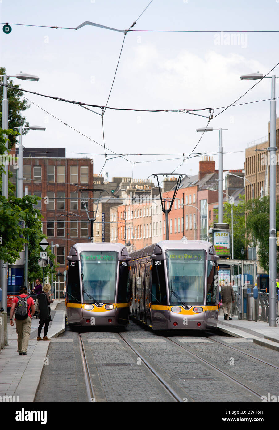 Ireland, County Dublin, Dublin City, Luas light rail trams at stop beside Saint Stephen's Green with people. Stock Photo