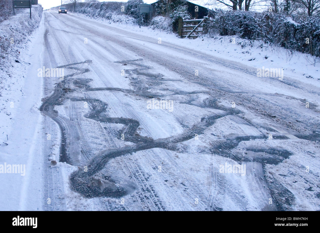 Skid and slip marks made by a car on an untreated icy, snow-covered road Stock Photo