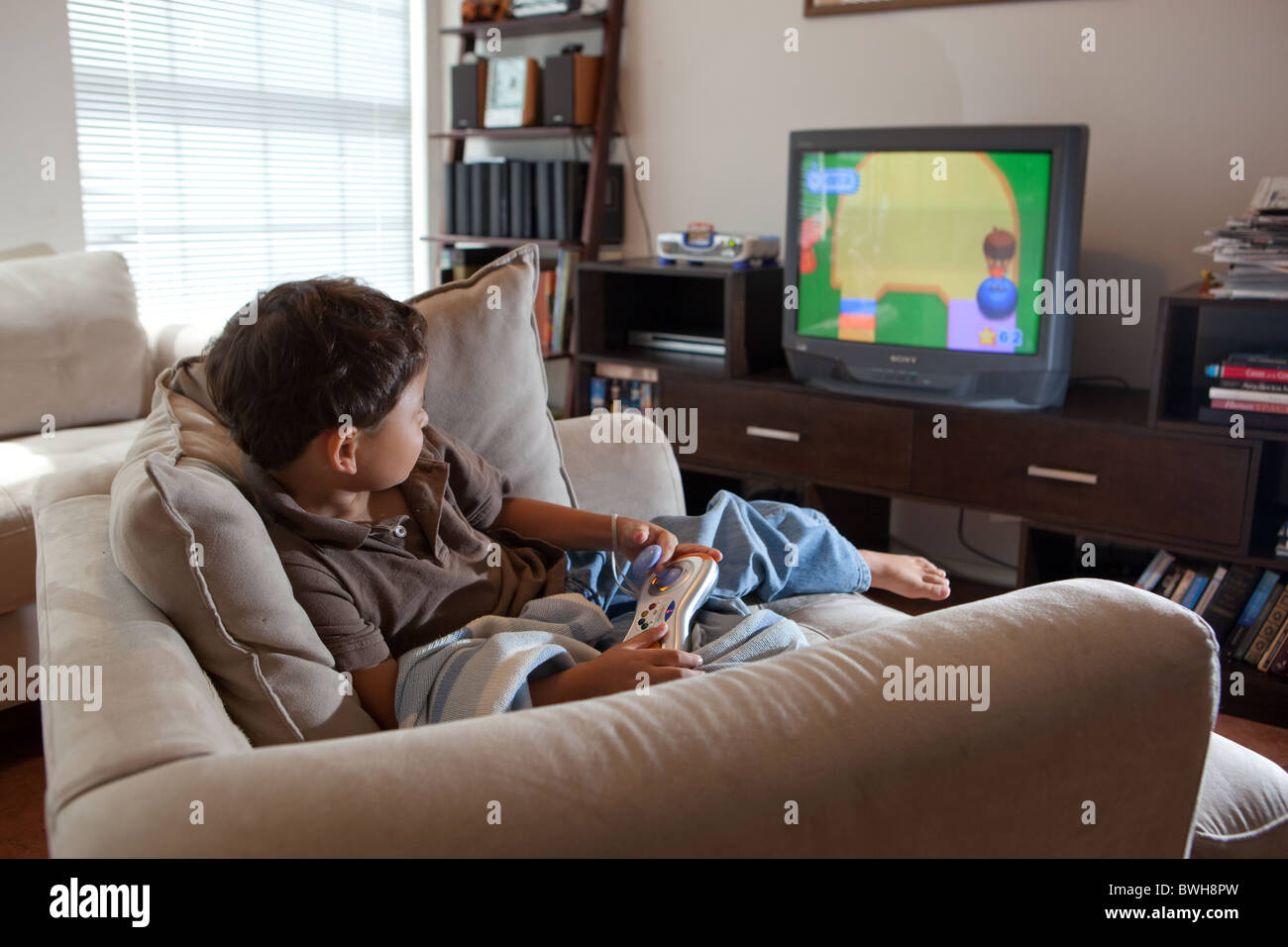 Four-year-old Mexican-American boy uses VTech V.Smile motion active  learning console to play video game on TV screen in his den Stock Photo -  Alamy