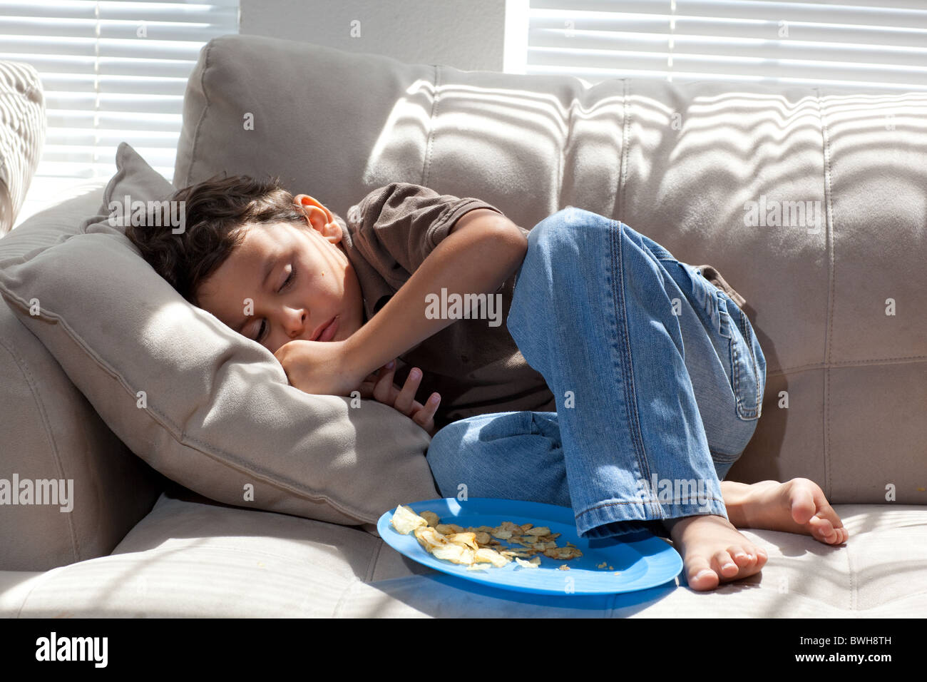 Four Year Old Mexican American Boy Eats Potato Chips For A Snack