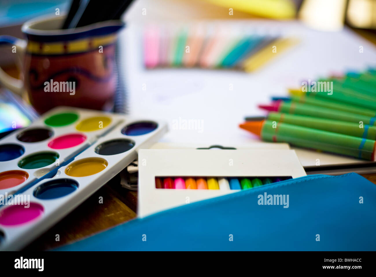 Assorted stationary color pencils, paint, paper and crayons placed on