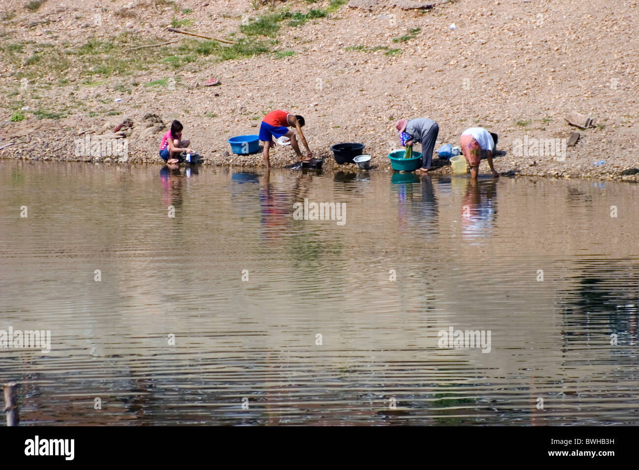 A group of people are washing clothes in a river in Nan, Thailand Stock