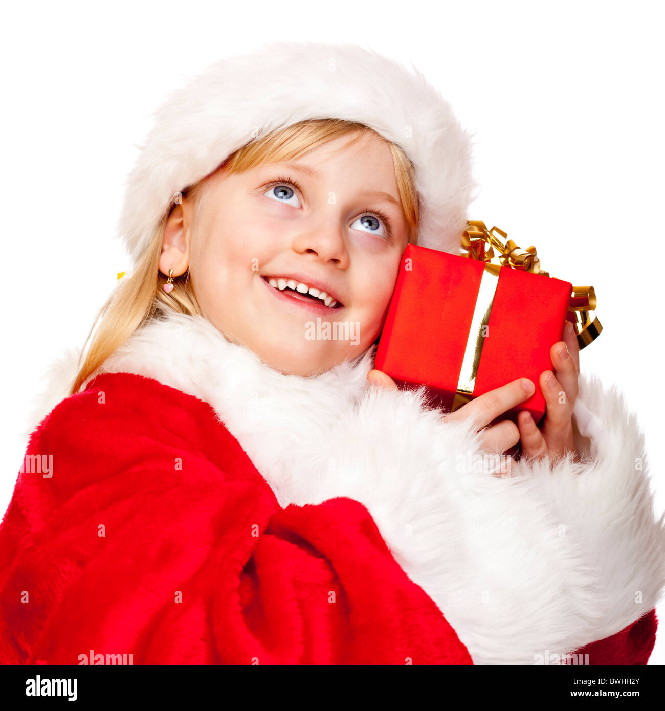 Young happy girl dressed as Santa Claus holds Christmas gift in hands.  Isolated on white background. Stock Photo