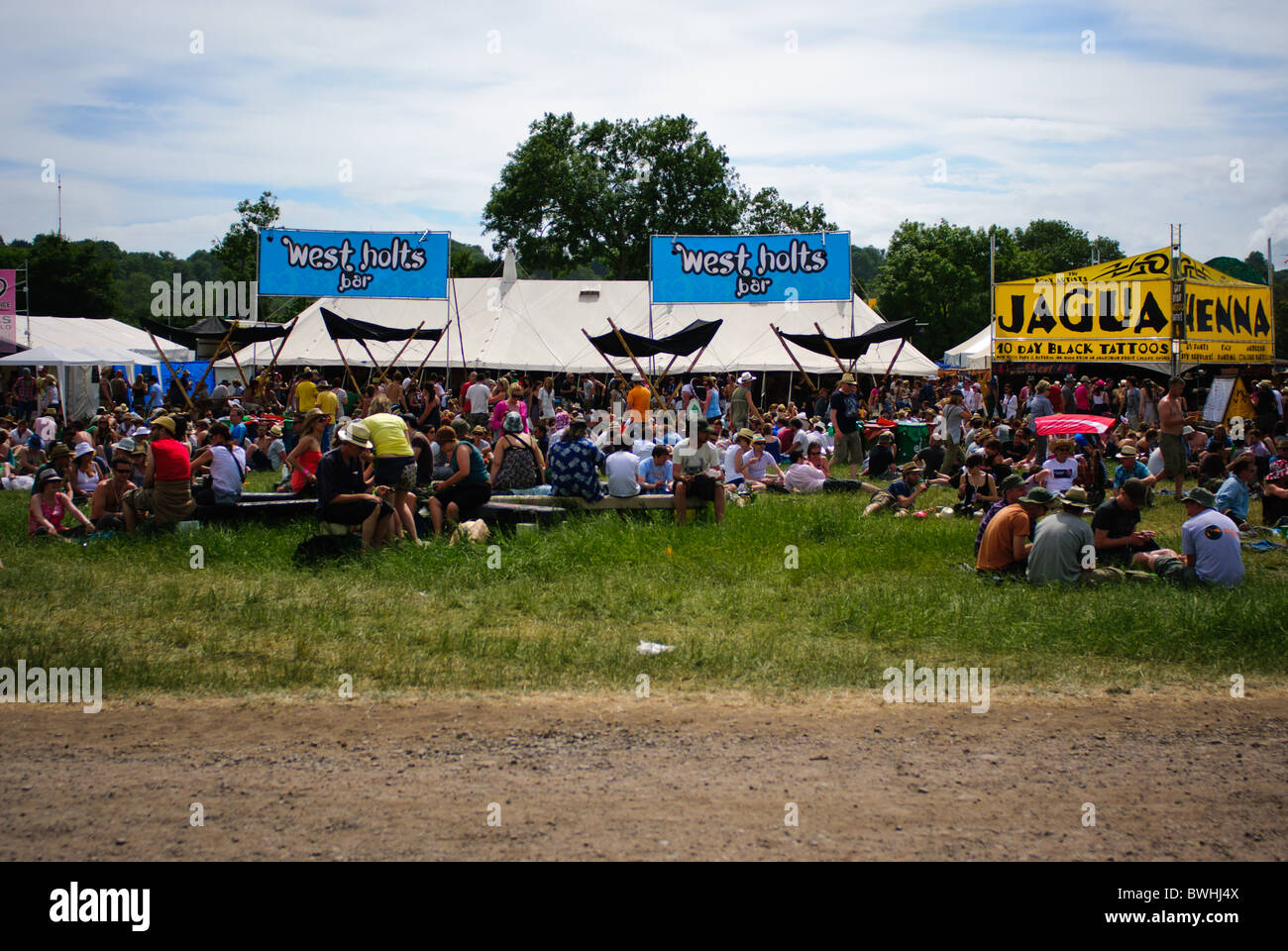 Festival revellers sitting outside at the West Holts bar at Glastonbury festival 2010 Stock Photo