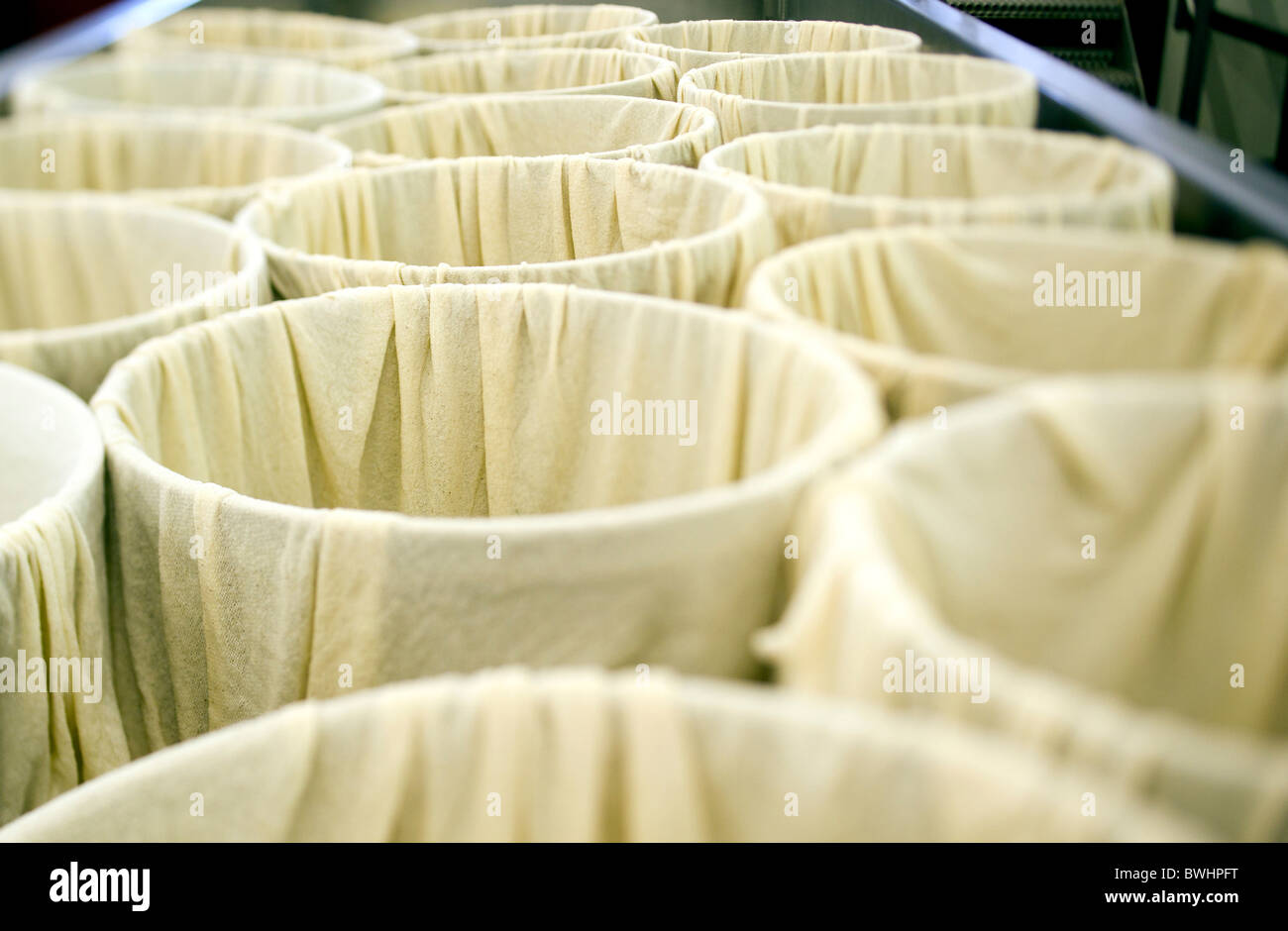 Muslin cloth in cheese moulds awaiting cheese curds at Quickes