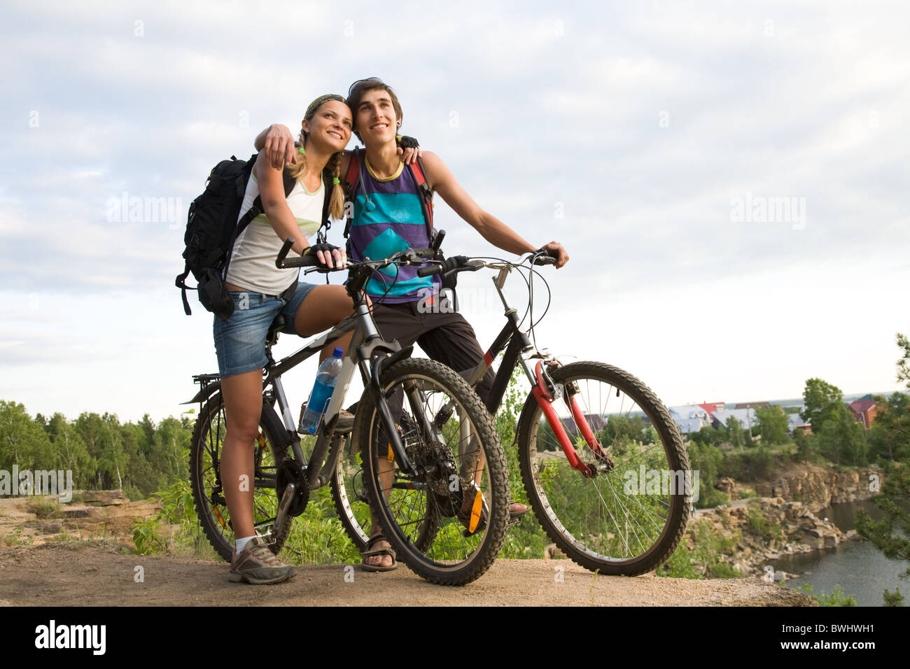 Couple of cyclers on their bikes embracing each other in the countryside Stock Photo