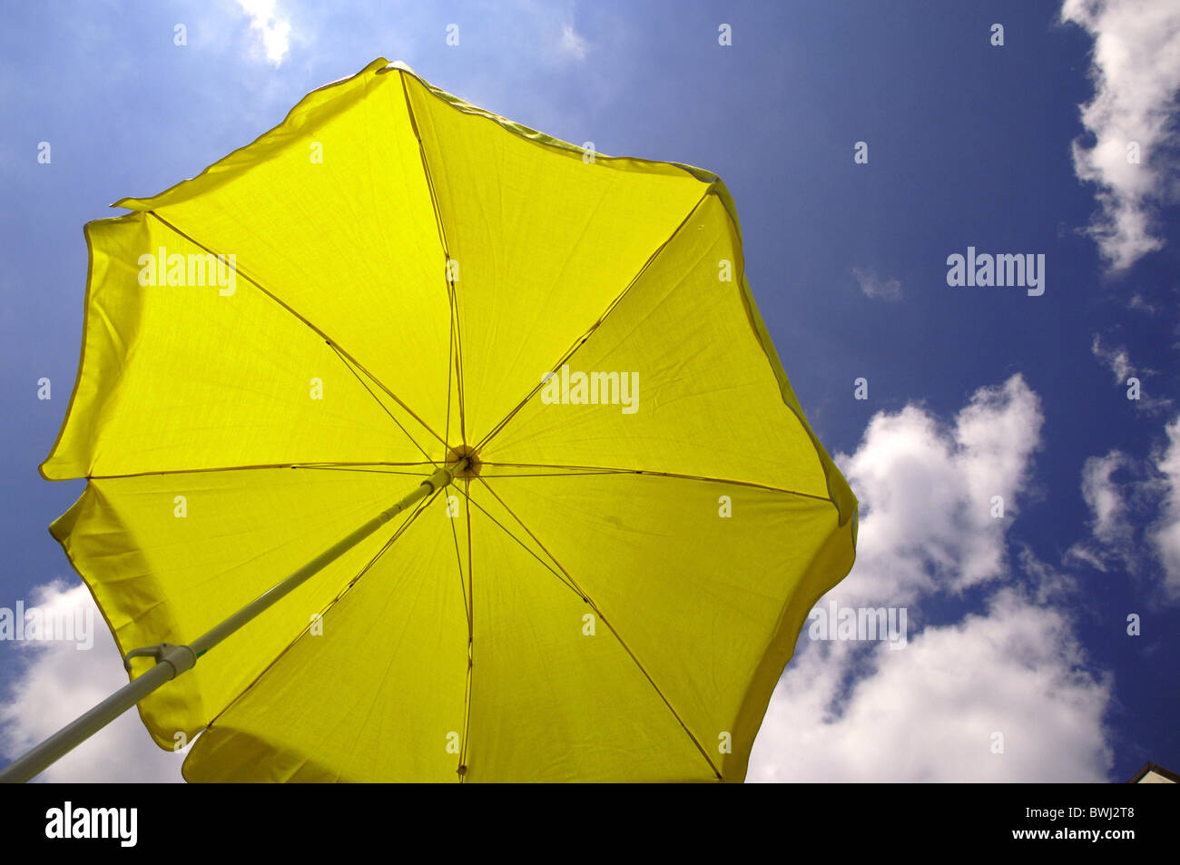 umbrella yellow sunshade UV protection sky sun cloud sky summer sunbath tanning shade shadow donator holi Stock Photo