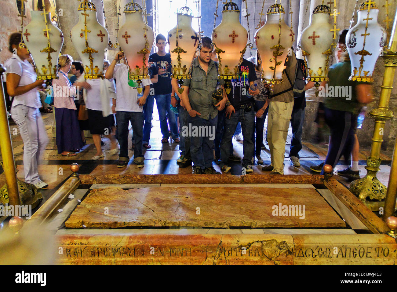 People praying around the Stone of Unction in the Church of the Holy Sepulchre in Jerusalem Stock Photo