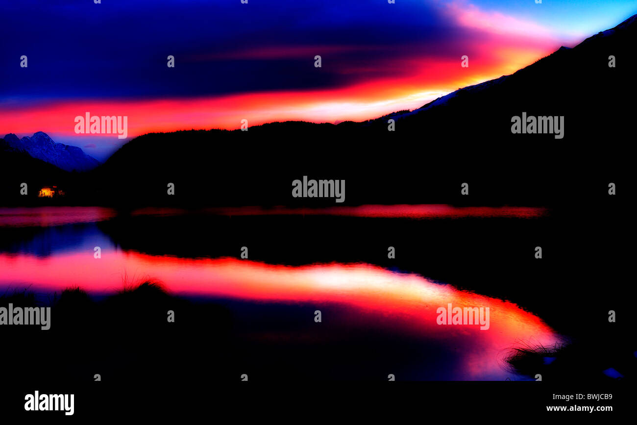 red sky at sunrise over wildsee lake seefeld austria colours digitally enhanced Stock Photo