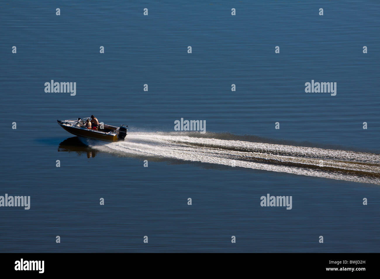 A speed boat makes a big wake on the Mississippi River. Stock Photo
