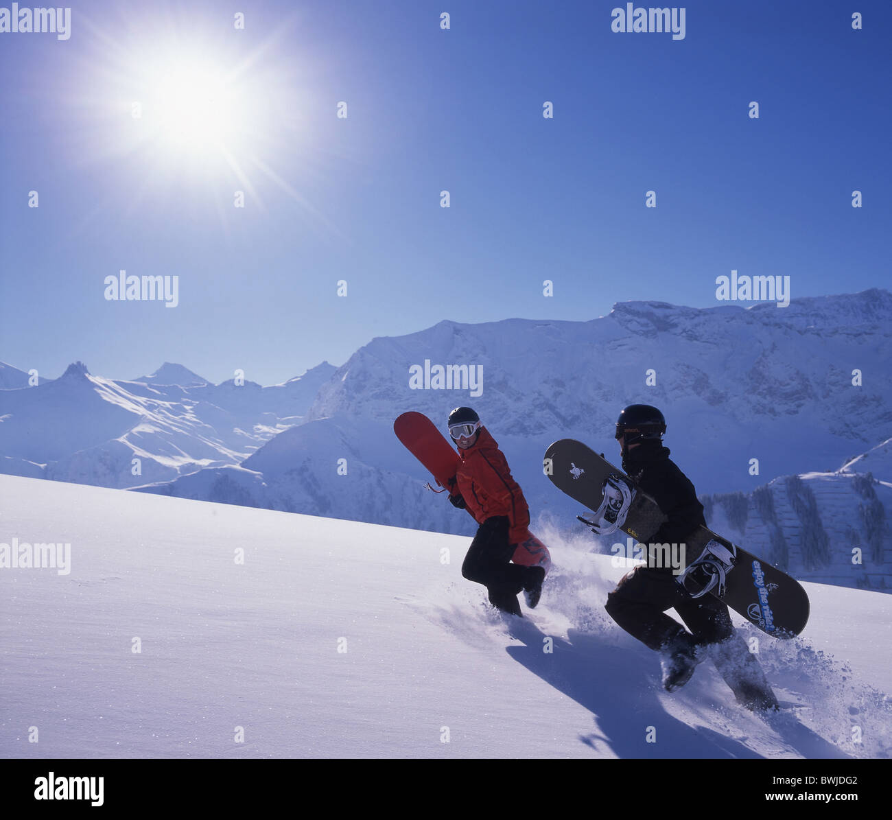 Two Snowboarder way up deep snow stampend snowboard Snowboarding snow mountains Alps Bernese Oberland Adelbod Stock Photo