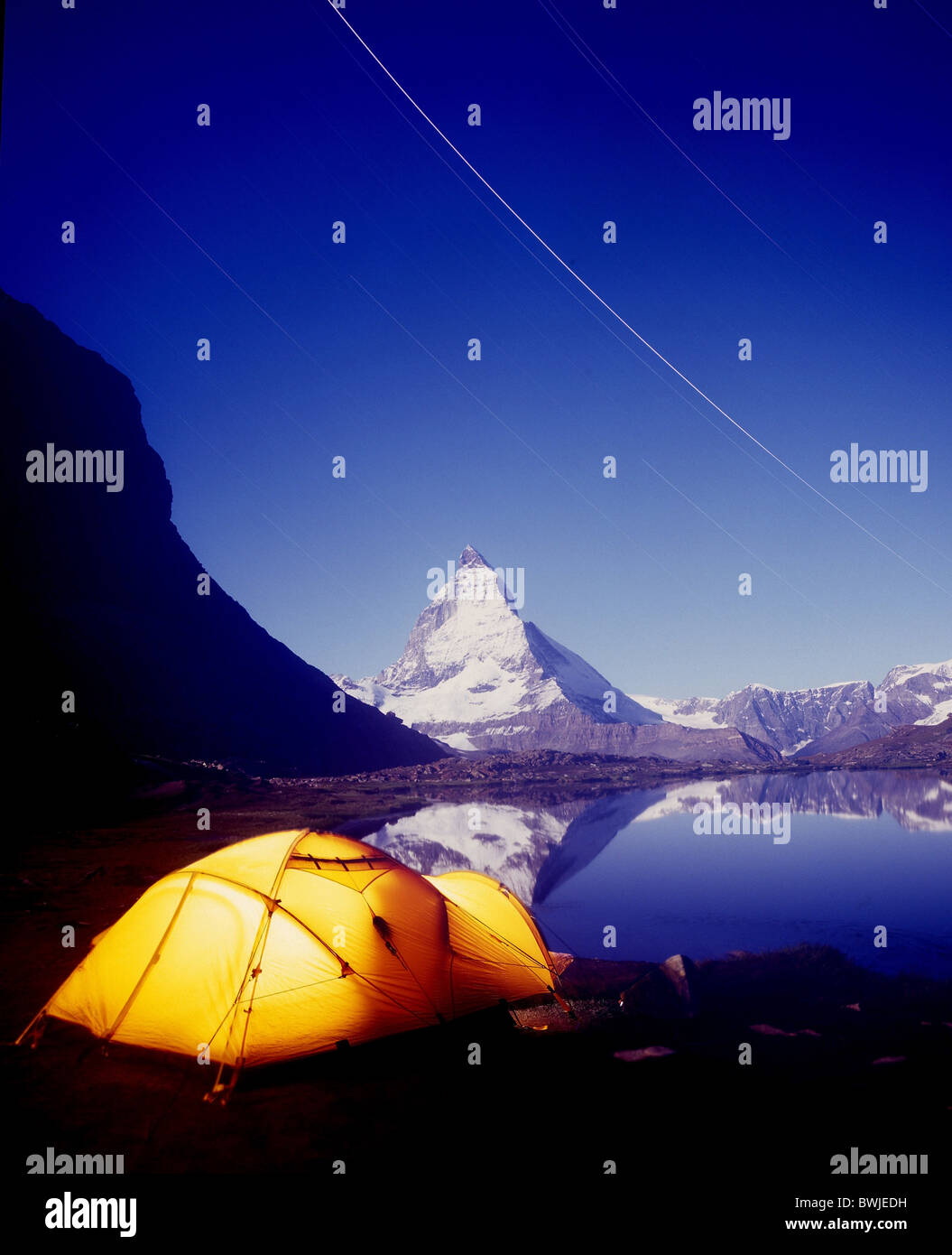 Matterhorn camping tent tent camp illuminated light lake mountain lake Riffelsee dusk twilight at night n Stock Photo