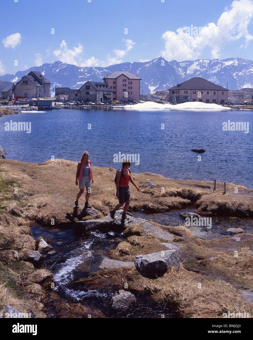 Two women woman travelers hiking Trans Swiss Trail Gotthard Gotthardpass pass alpine pass lake mountains A Stock Photo
