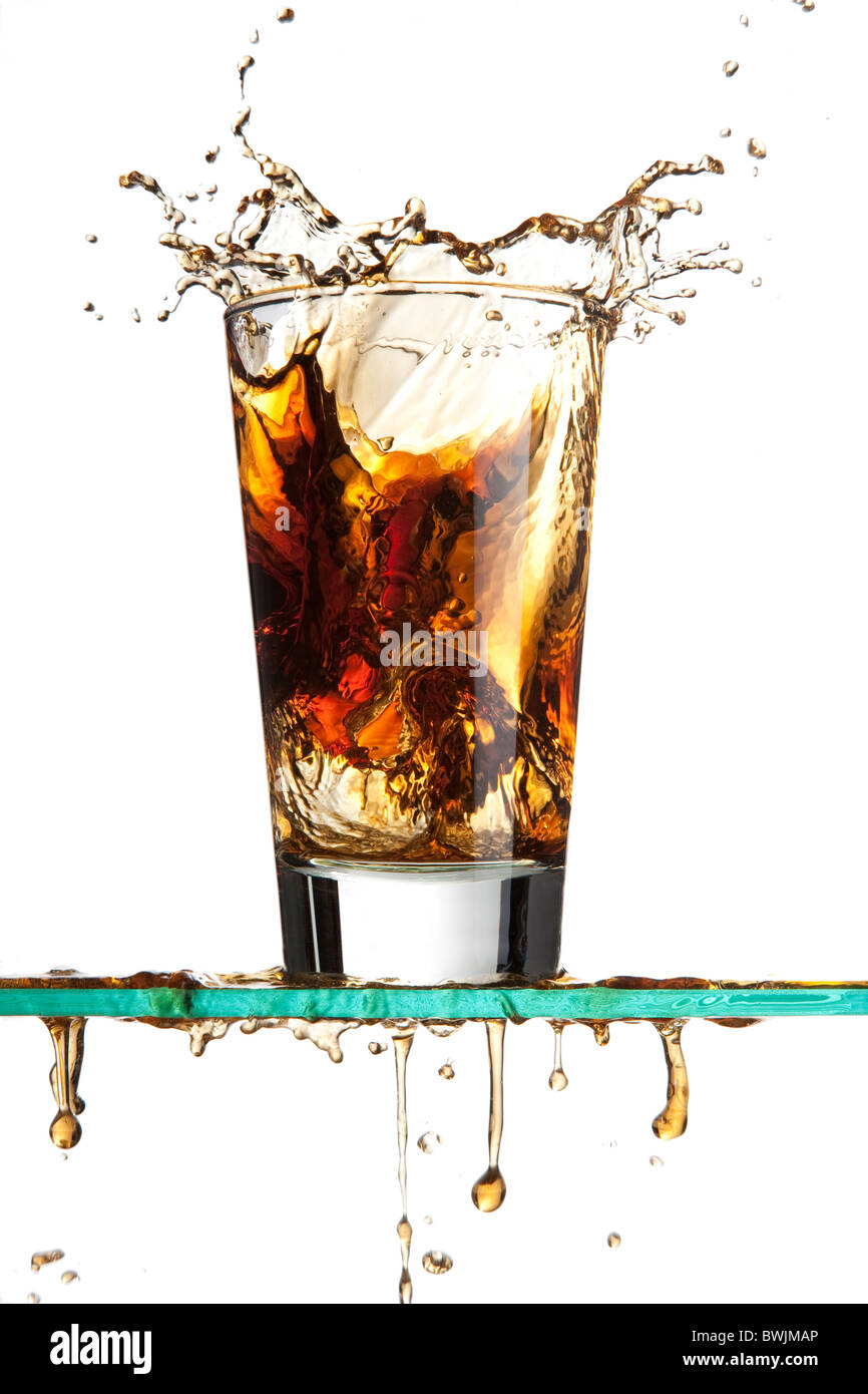 Ice cube dropped into a soda creating a splash Stock Photo