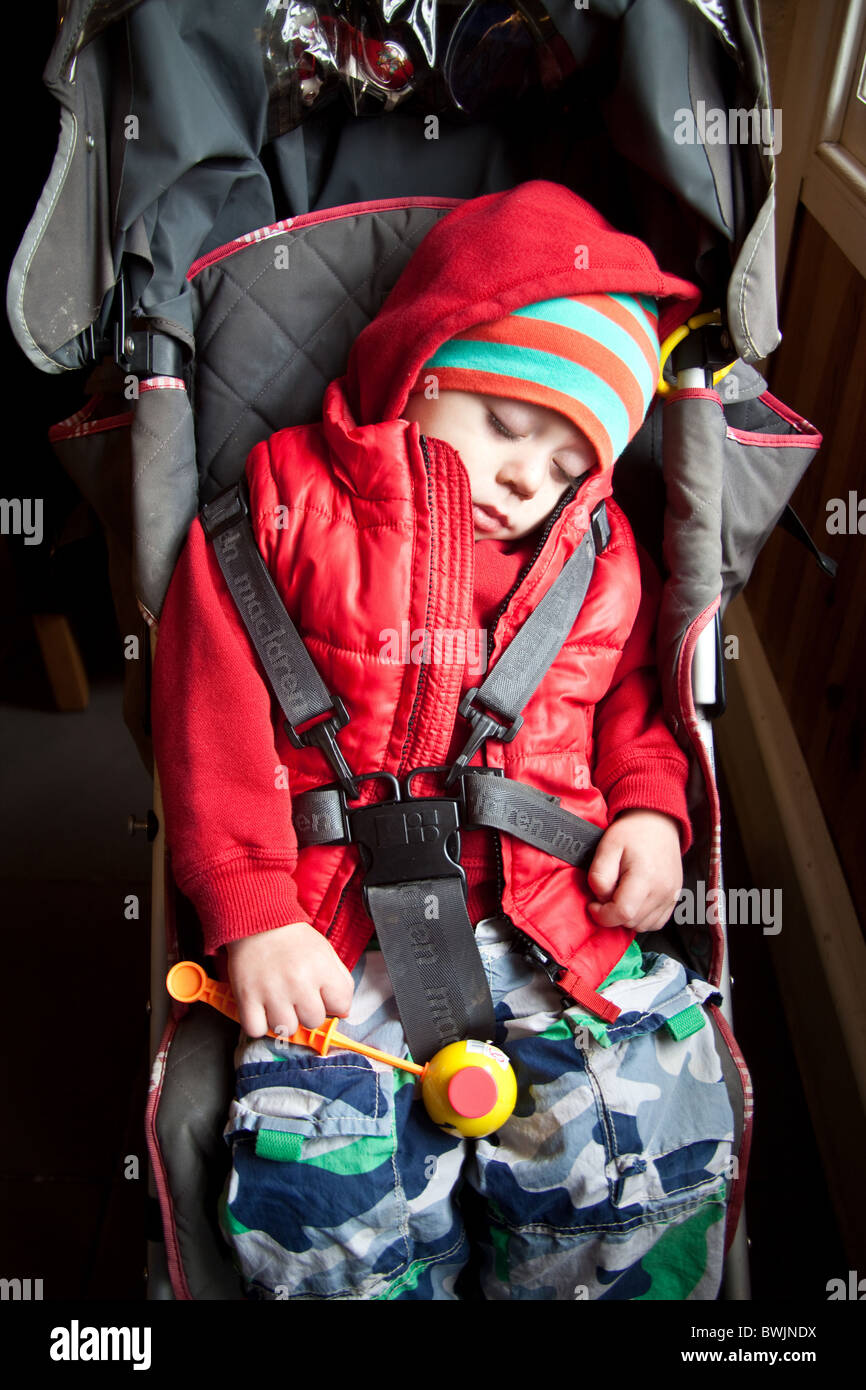 Young boy 19 months asleep in a pushchair, Totnes Devon, England, U.K Stock Photo