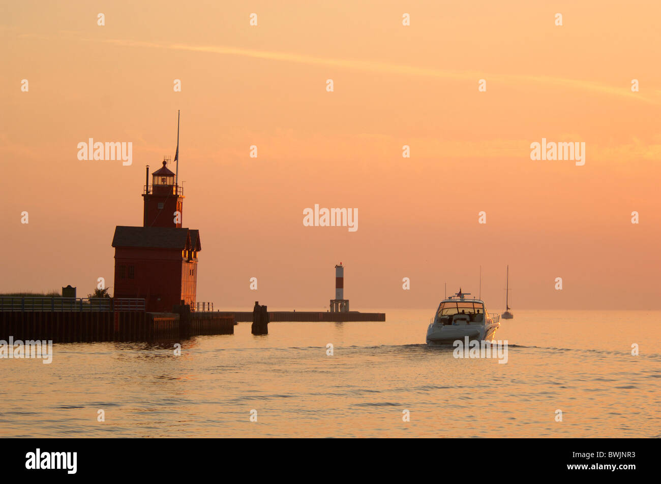 Big Red Lighthouse lighthouse red Boat motorboat mood dusk twilight Michigan lake shore lake Lake Michigan Stock Photo