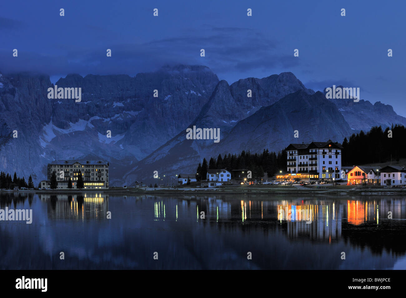 The mountain range Gruppo del Sorapis and hotels at night along lake Lago di Misurina in Auronzo di Cadore, Dolomites, Italy Stock Photo