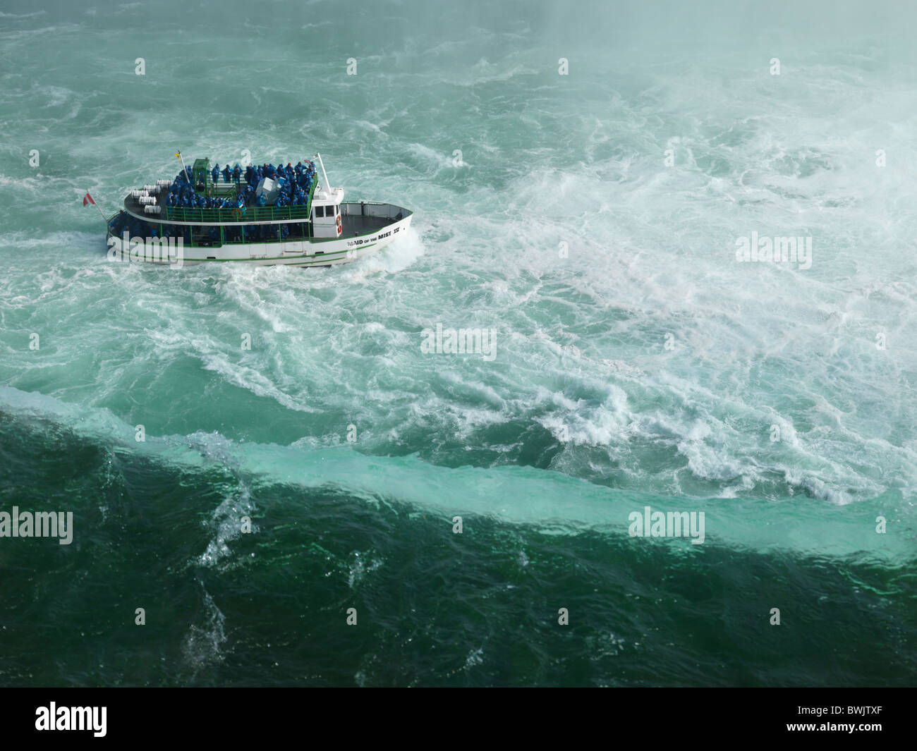 People on Made of the Mist boat ride approaching Niagara Falls Horseshoe edge Stock Photo