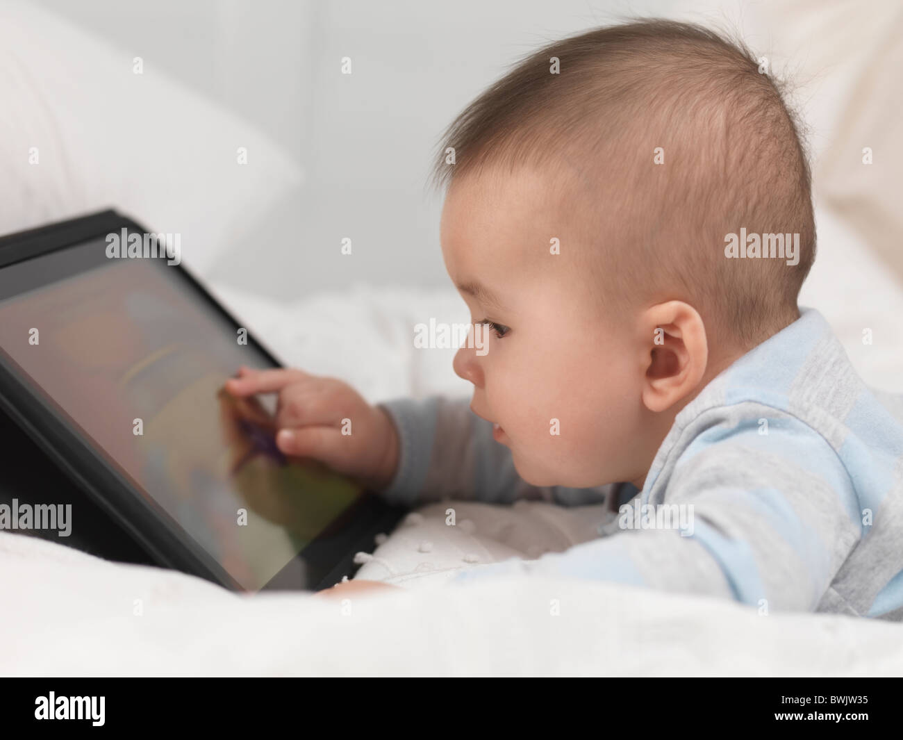 Six month old baby boy playing with a tablet computer Stock Photo