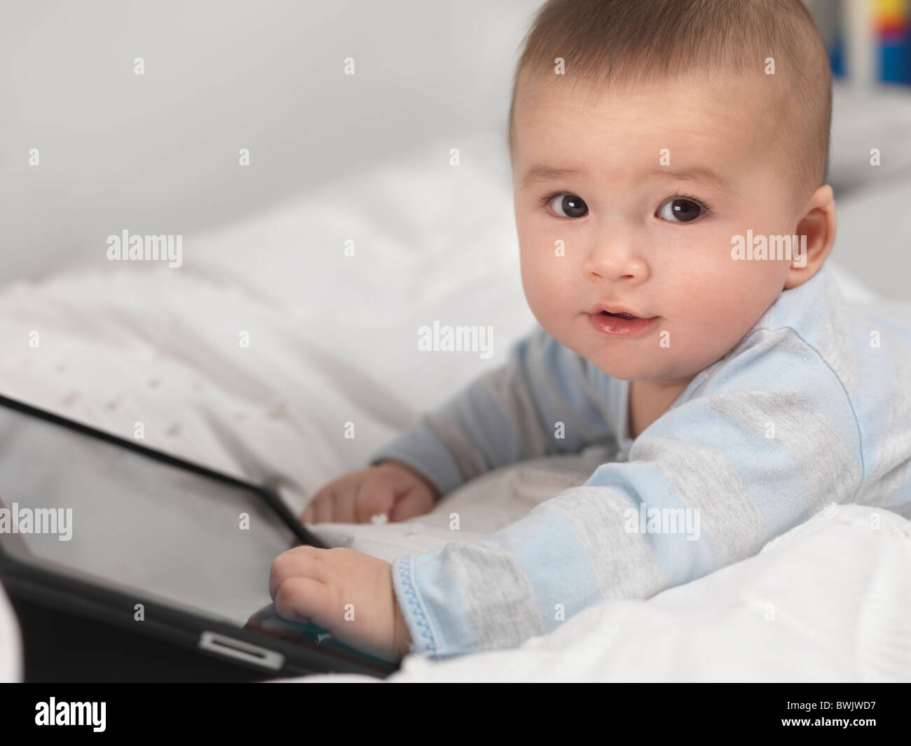 Six month old baby boy playing with Apple iPad tablet computer Stock