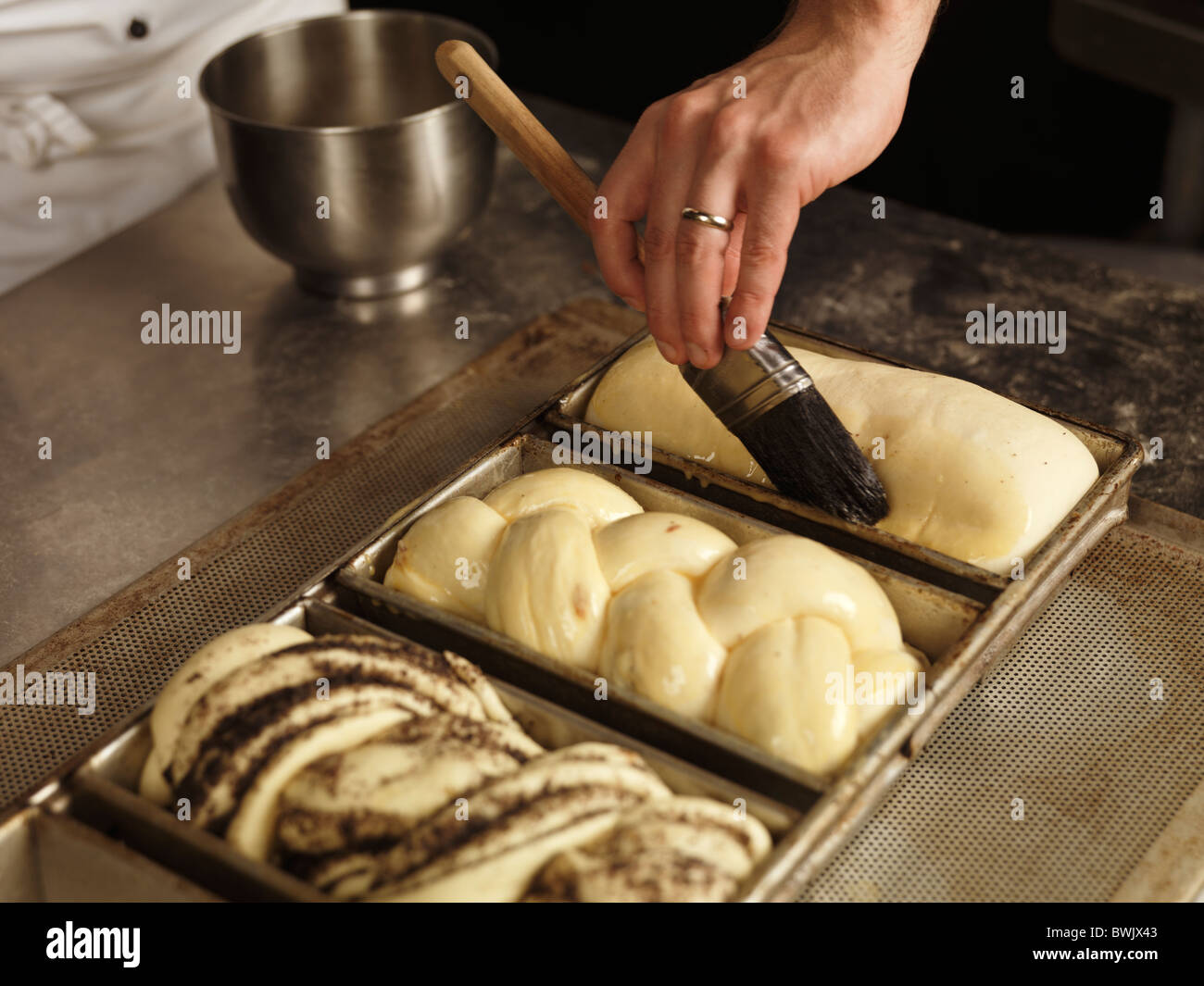 Baker brushing egg yolk glazing on sweet bread Stock Photo Alamy