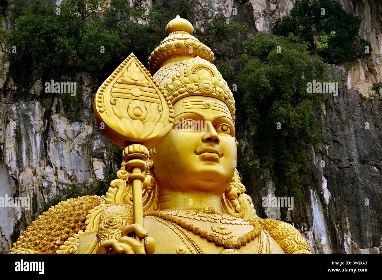 The tall Murugan stands by the stairs climbing the Batu Caves, near Kuala Lumpur, Malaysia Stock Photo