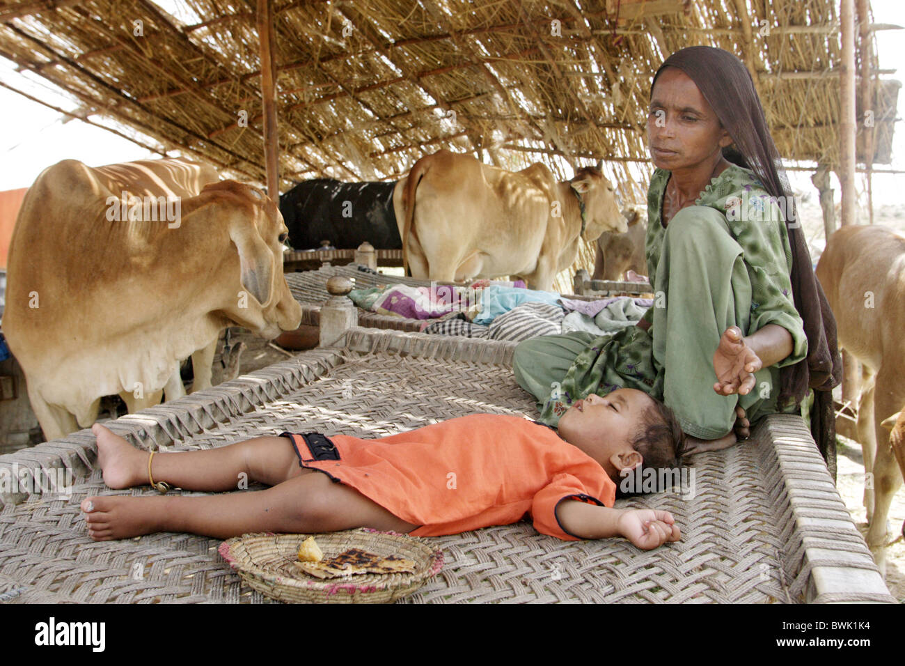 Woman and child in provisional emergency accommodation for refugees, Dadu, Pakistan Stock Photo