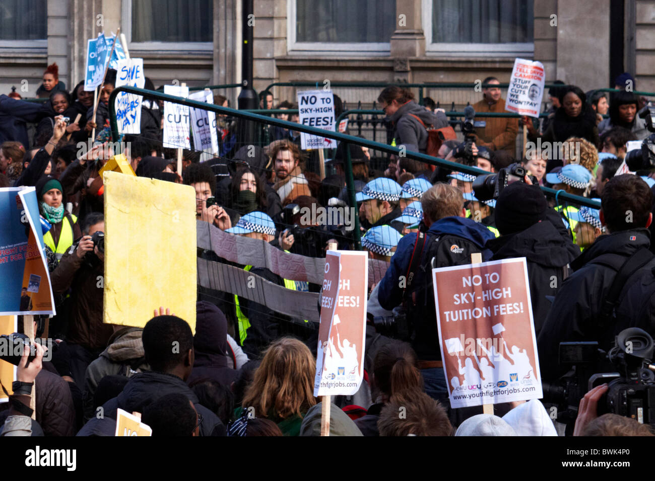 LONDON, UK. Demonstrators throw a large metal fence panel at police ...