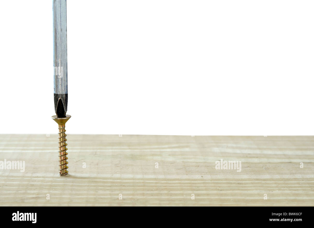 screwdriver screwing a screw in a wood plank Stock Photo Alamy