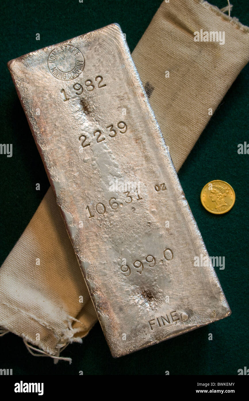 Large Homestake Mining Company Silver Bullion Bar - 106.31 Ounces - Lead, South Dakota Mine - Gold Coin for Scale Stock Photo