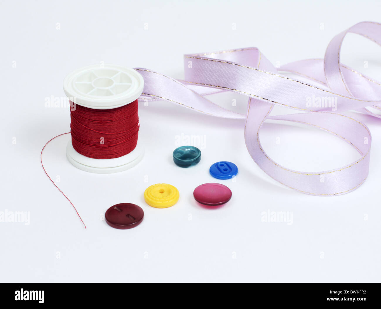 Threads with colored buttons and a pink tape Stock Photo - Alamy