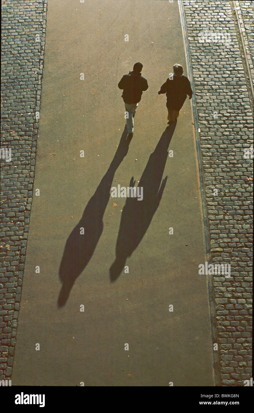 person pedestrian cobblestones pavement two persons silhouette shade Germany Europe Stock Photo