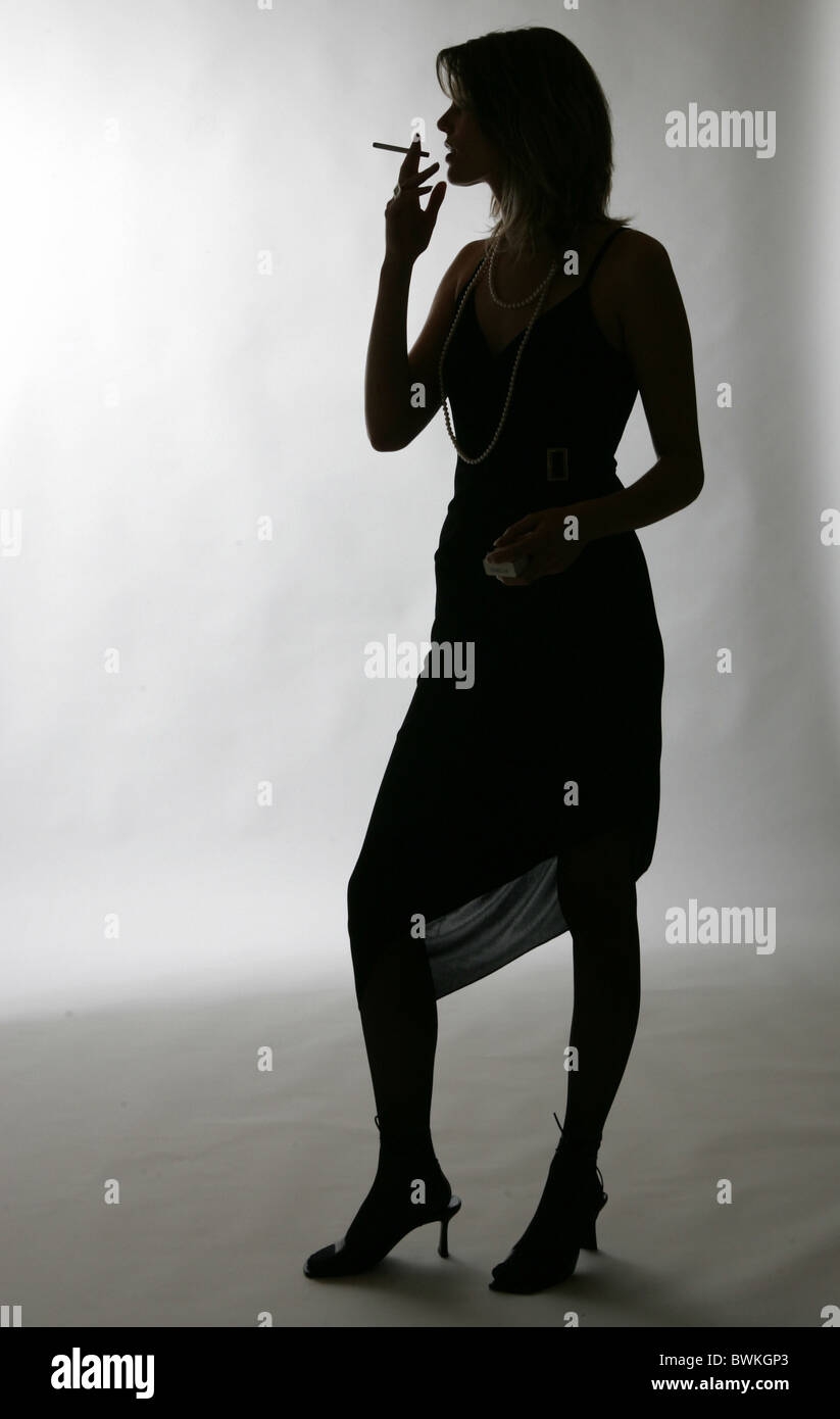 woman whole figure smoking silhouette studio Inside studio shot cigarette dress elegant Standing standing p Stock Photo