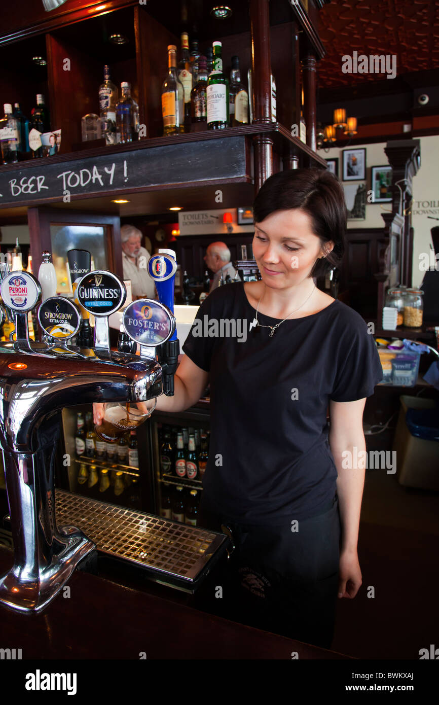 Barmaid waitress at pub tapping draught beer Stock Photo