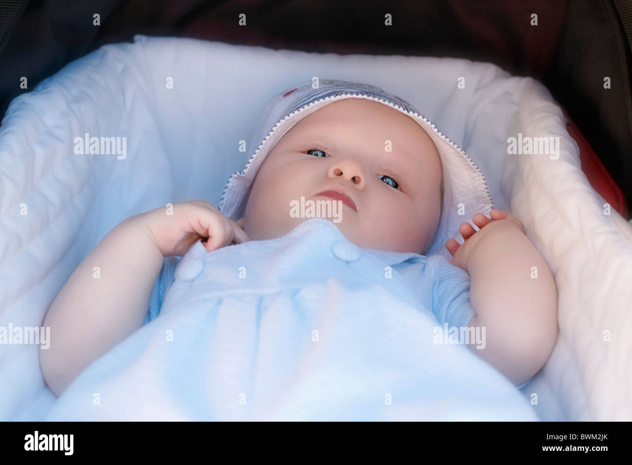 Baby boy 7 Months old toddler portrait child children one person lying carriage hat buggy Stock Photo