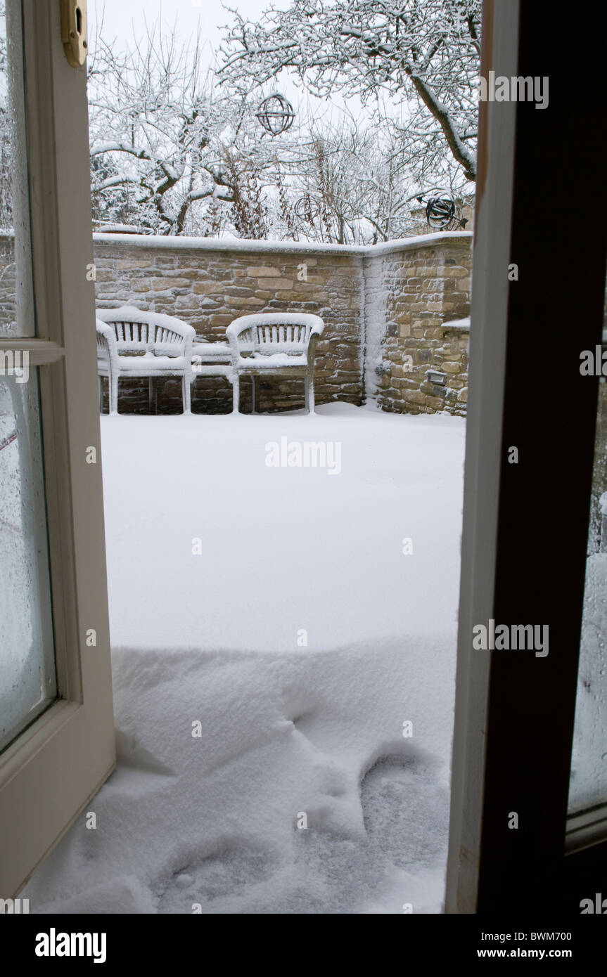 Open patio door looking out onto a garden with deep snow Stock Photo