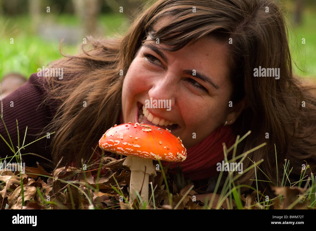 girl simulating that is going to eat a poison red mushroom Stock Photo