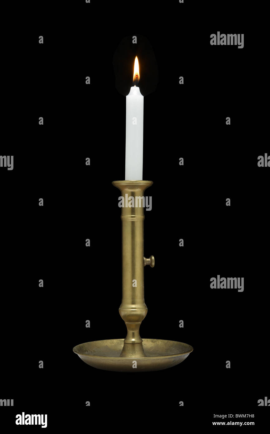 Lit candle in a brass candle holder. Stock Photo