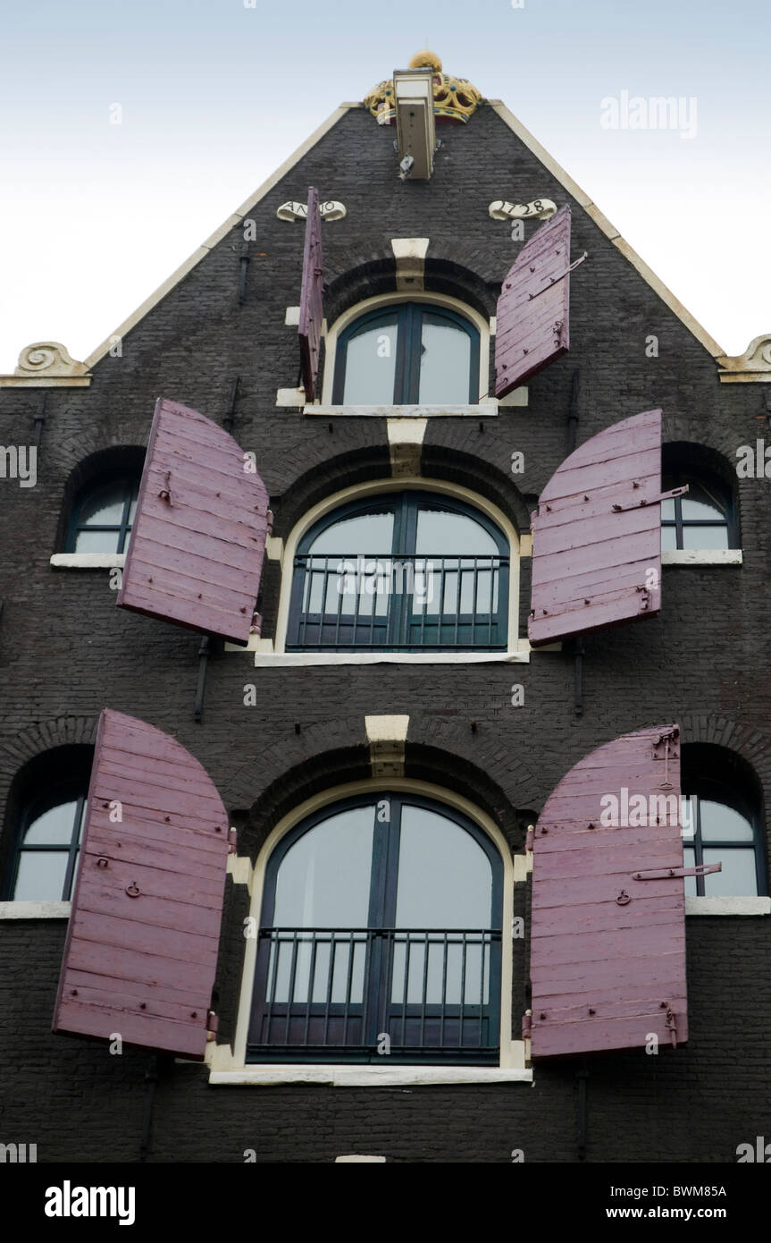 pink shutters on a tall building, Amsterdam Stock Photo