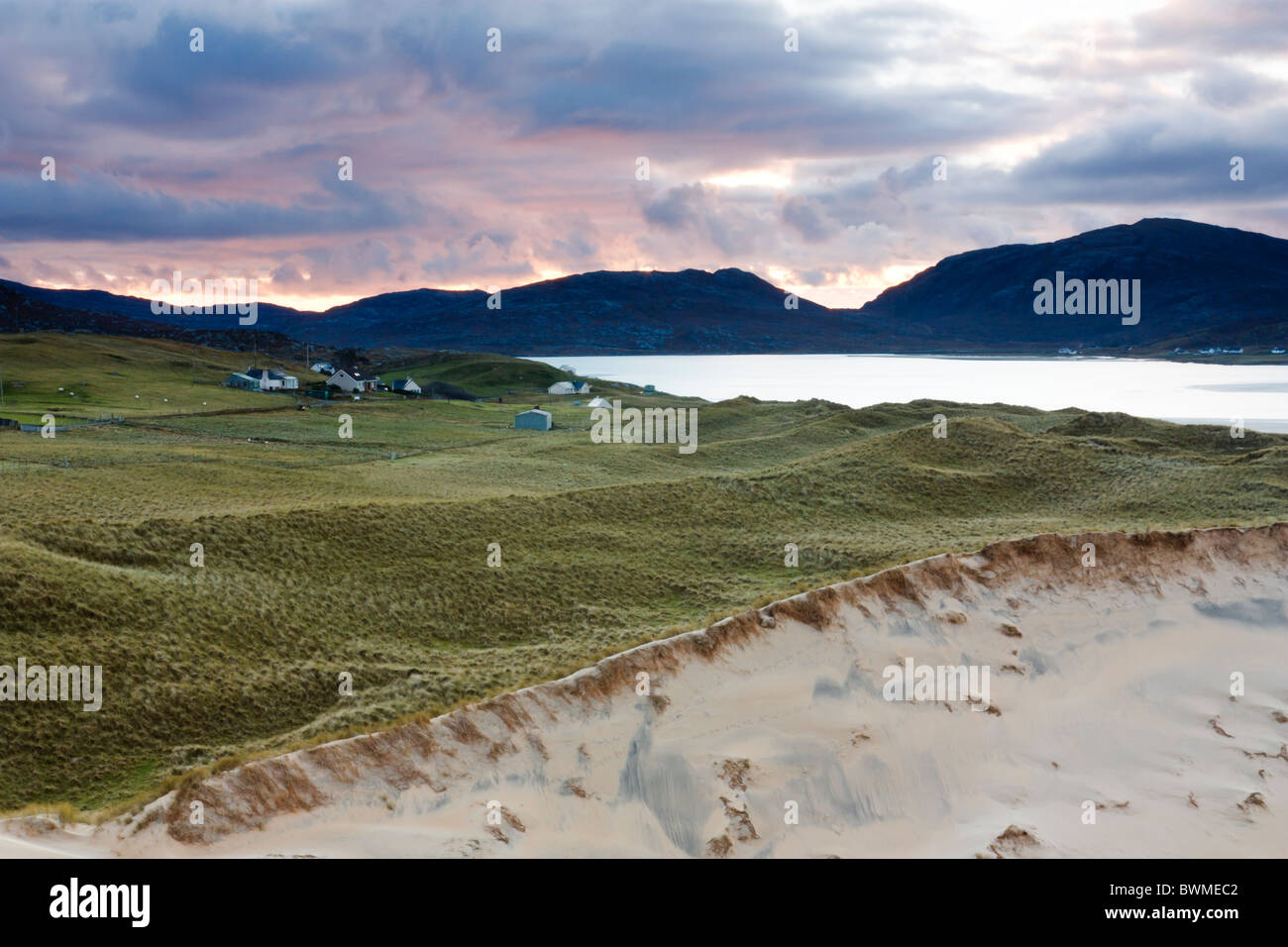 A cluster of houses at Luskentyre seen from the sand dunes under purple dawn light Stock Photo
