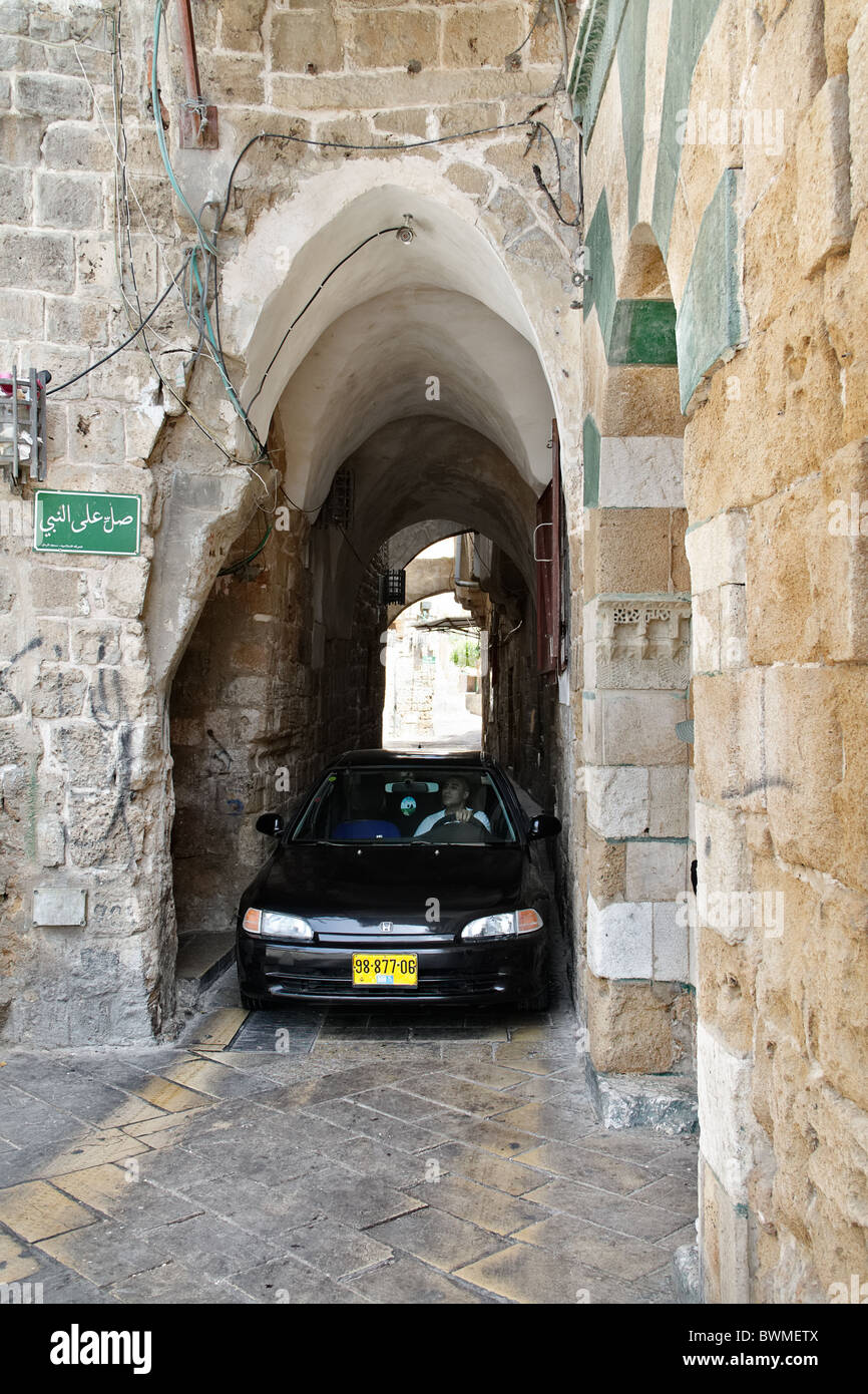 A car in the old street of Akko or Acre in northern Israel Stock Photo