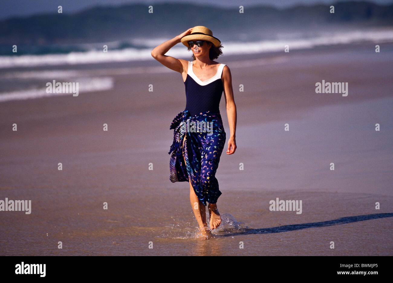 Woman walking along beach, Australia  (released) Stock Photo