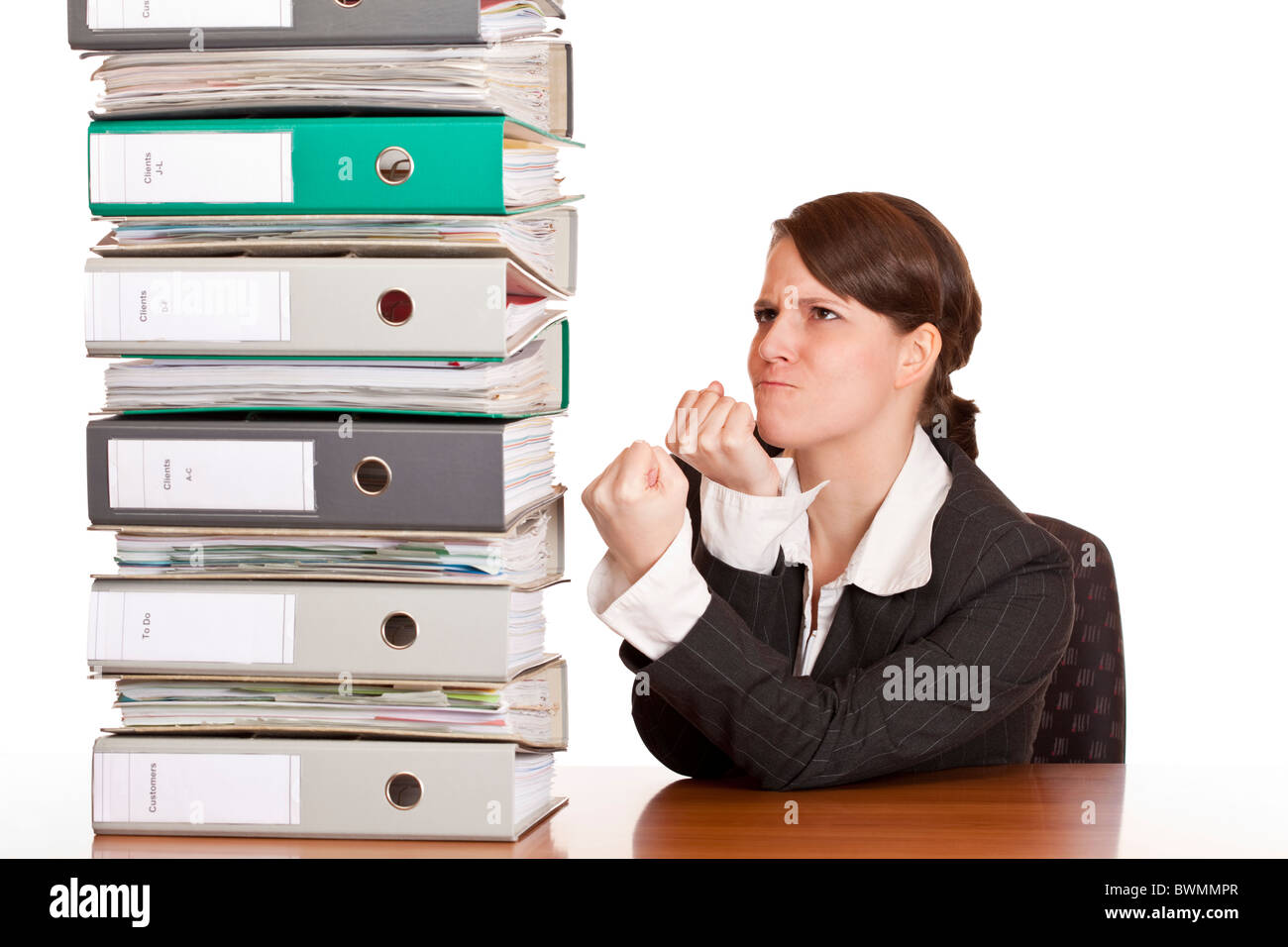 Business woman holds fists to file folder stack. Isolated on white background. Stock Photo