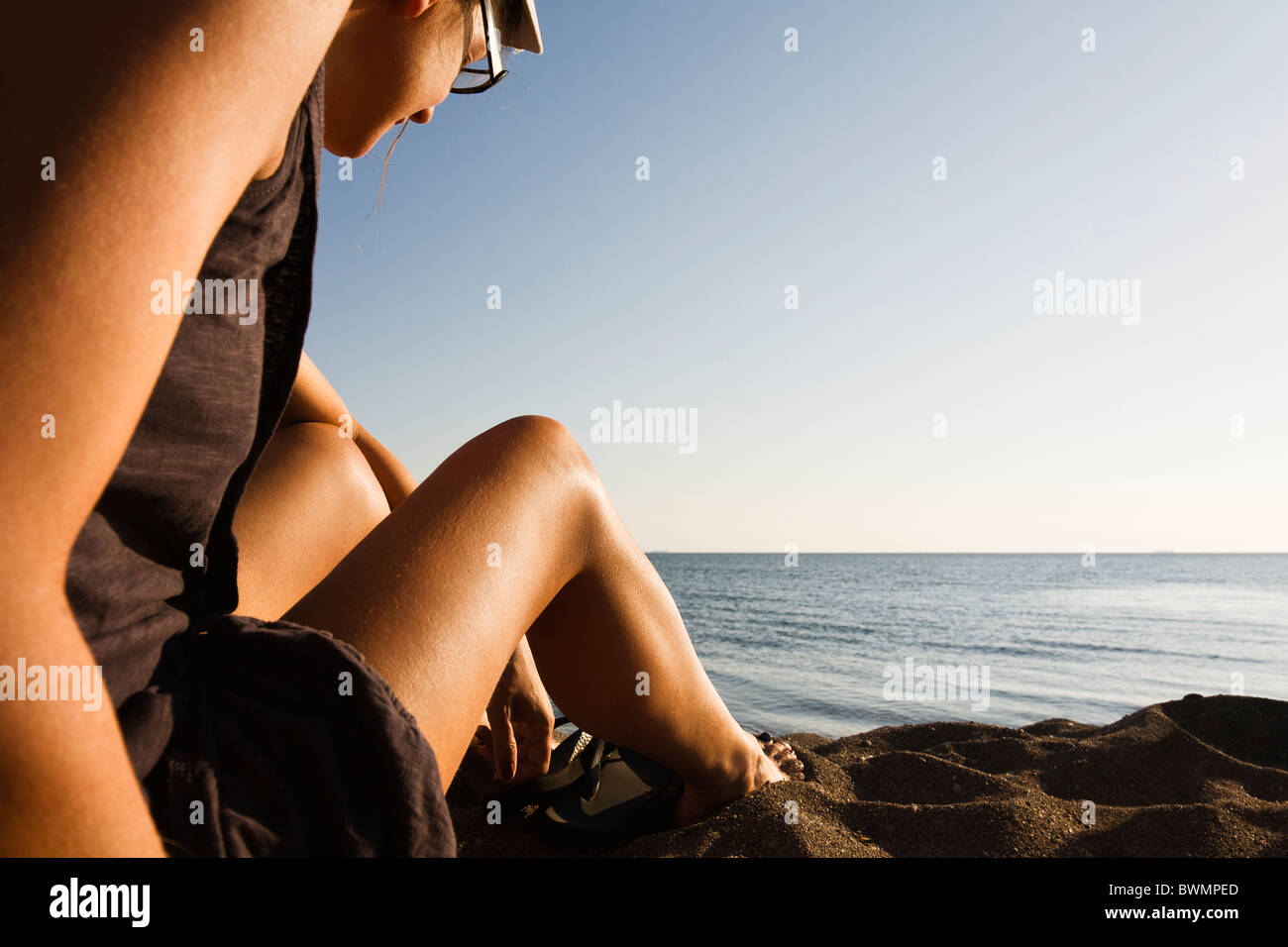 Woman sitting on the beach Stock Photo