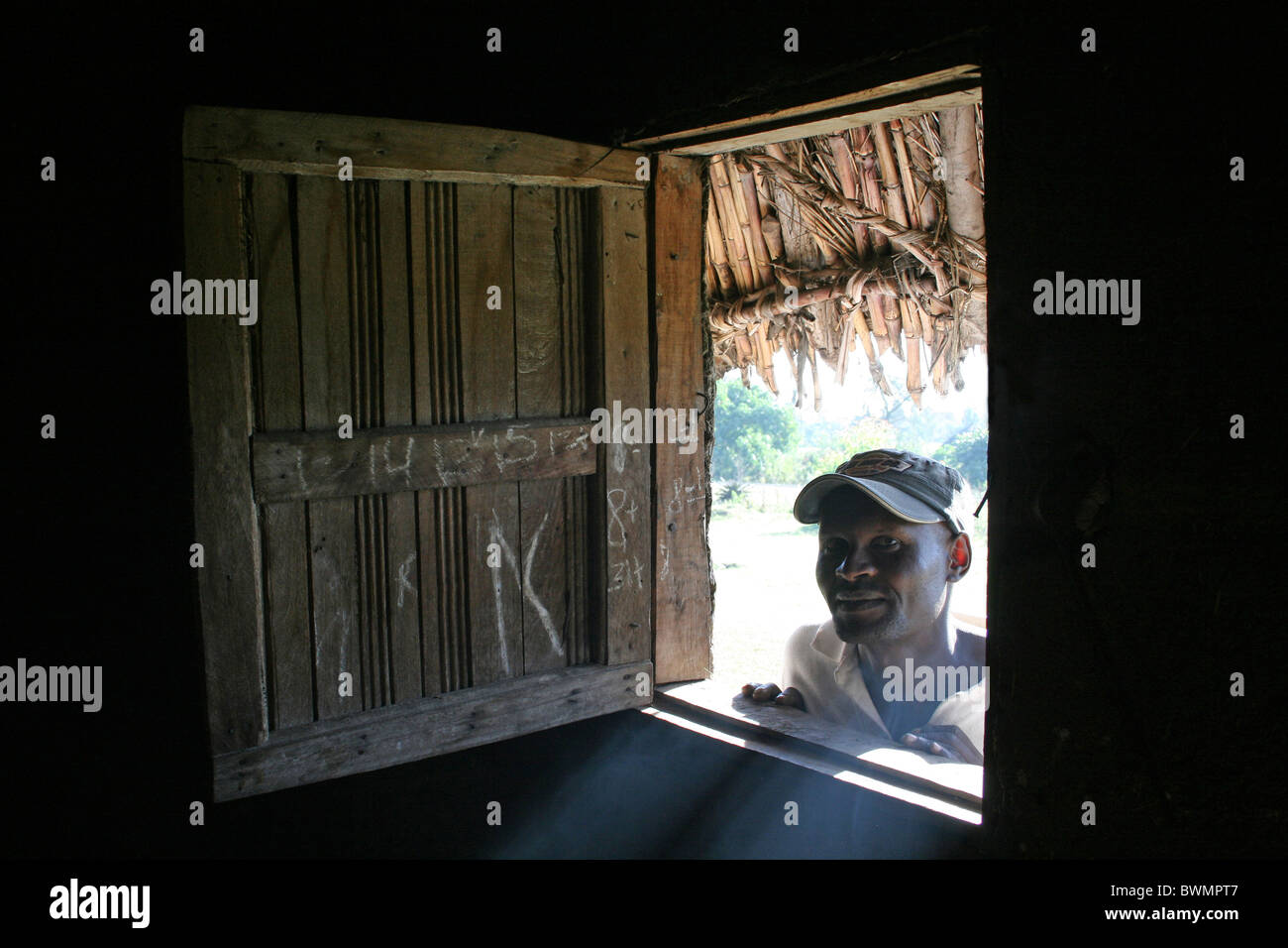Ethiopian Man Looking Through Wooden Window Of His Hut Stock Photo