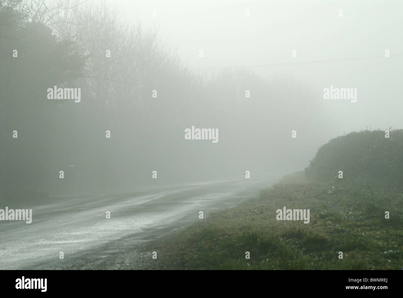 Mist and Fog Causing Dangerous Driving Conditions on Country Road in Northamptonshire, UK Stock Photo