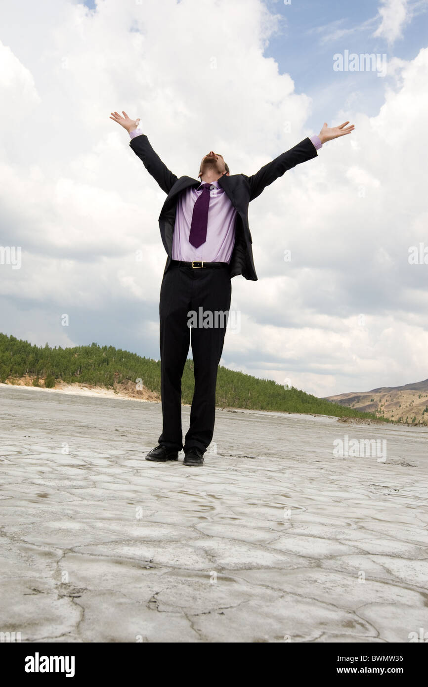 Photo of elegant businessman standing and raising his arms outdoors in ...