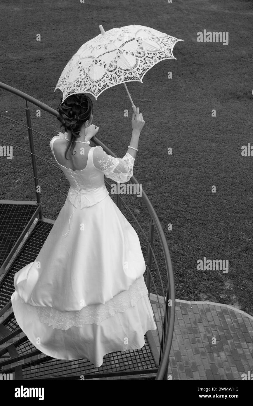 Black and white photo. Bride with umbrella waiting for her beloved. Stock Photo