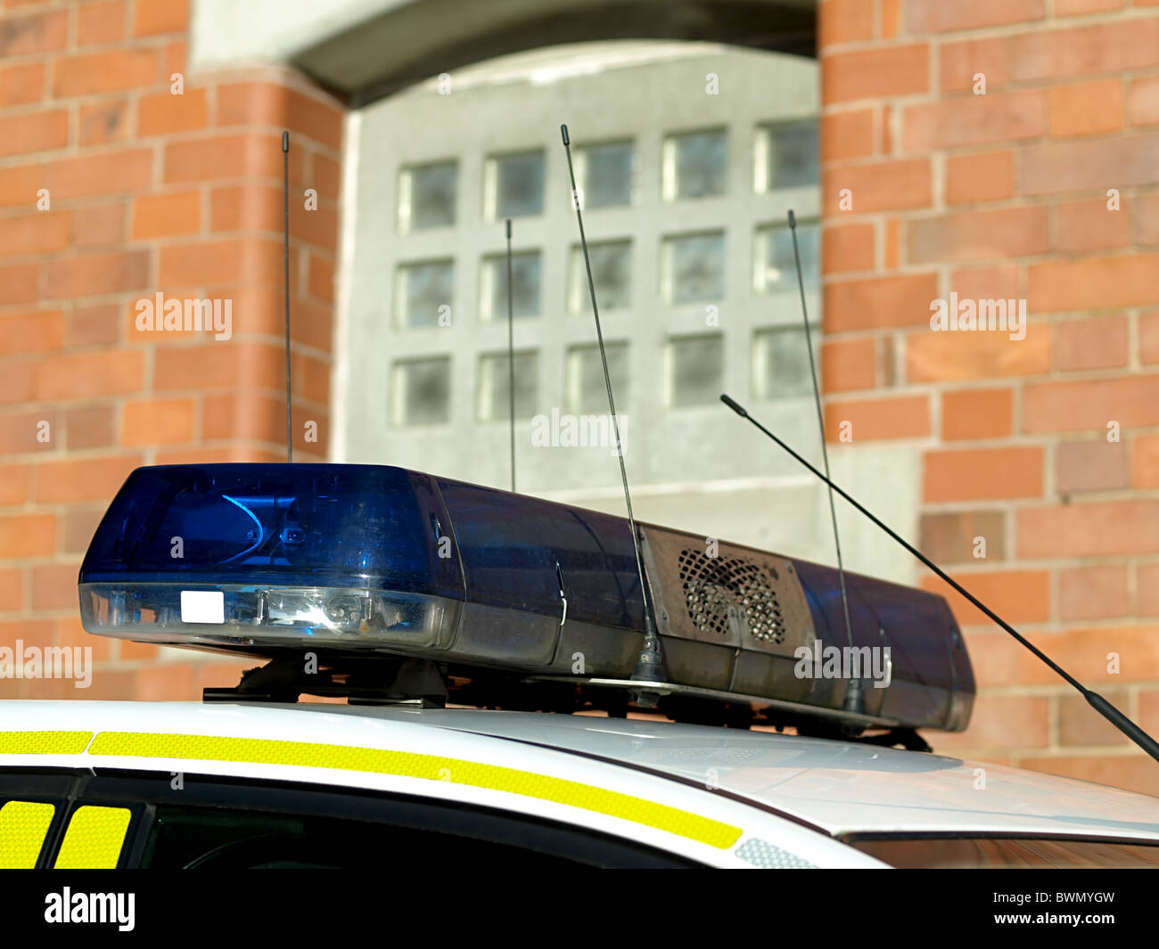 Police car blue roof light in front of prison cell window Stock Photo